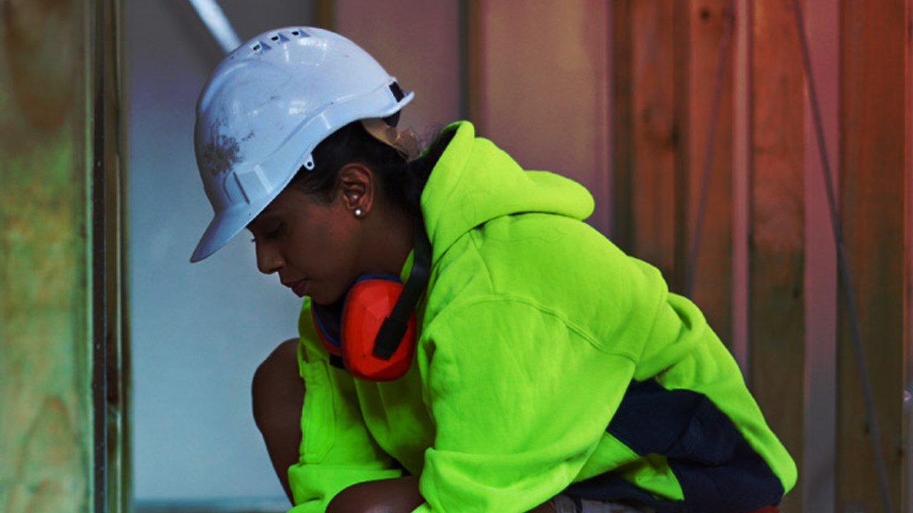 Female worker using tape measure at site.