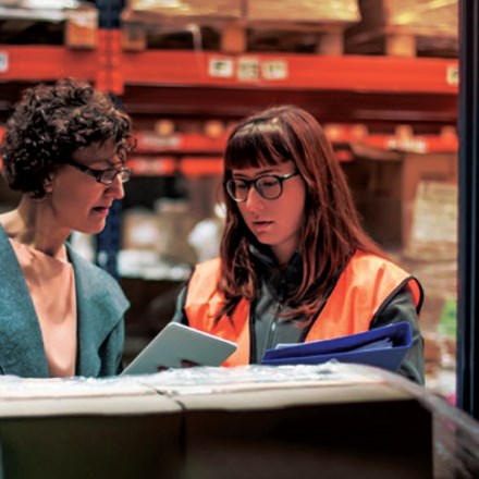 Two people in a factory looking at business solutions.
