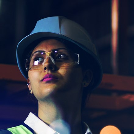 Lady with a white hard hat and safety goggles