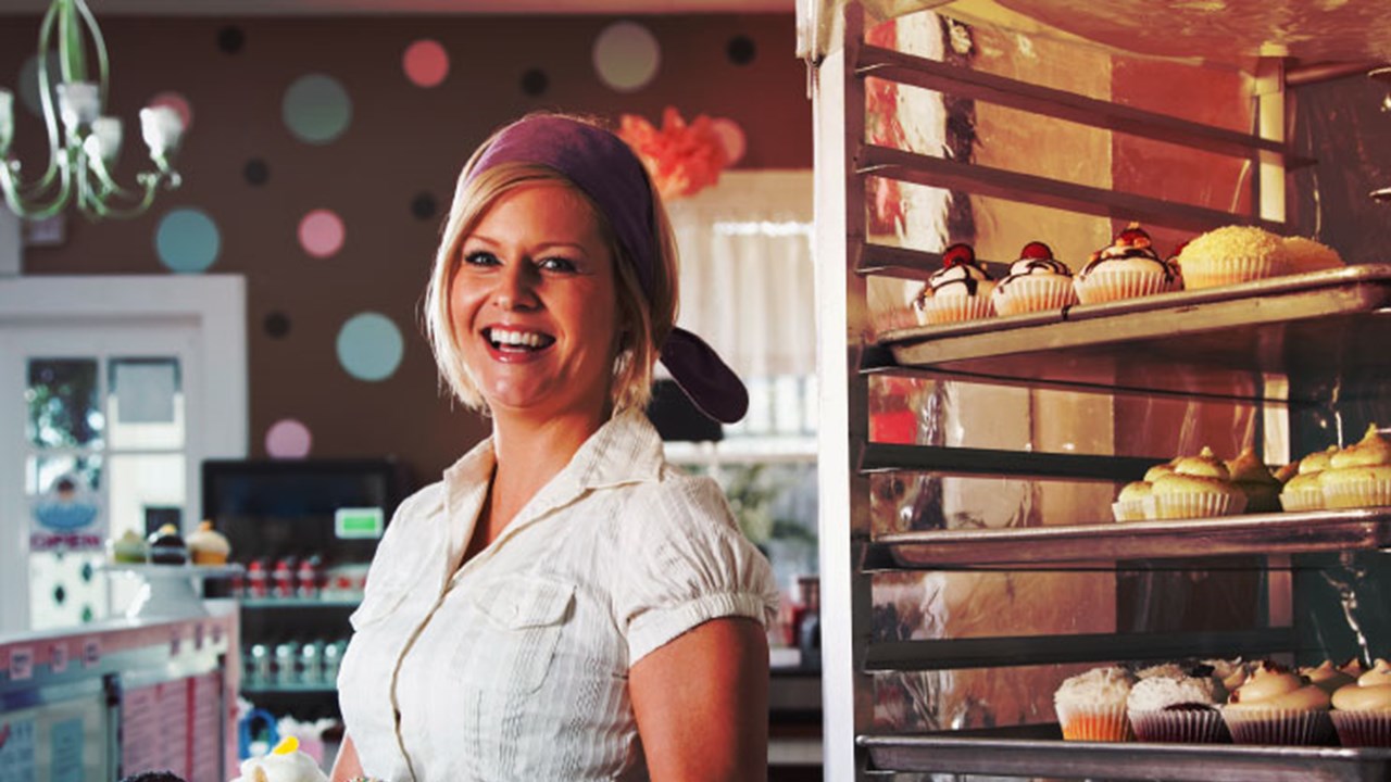 Woman bakery owner smiling to the camera after setting up her ERP system.   
