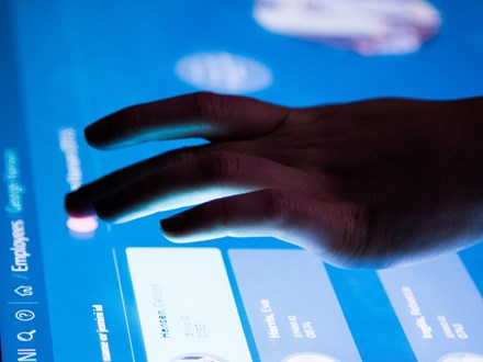 Hand touching a digital screen.