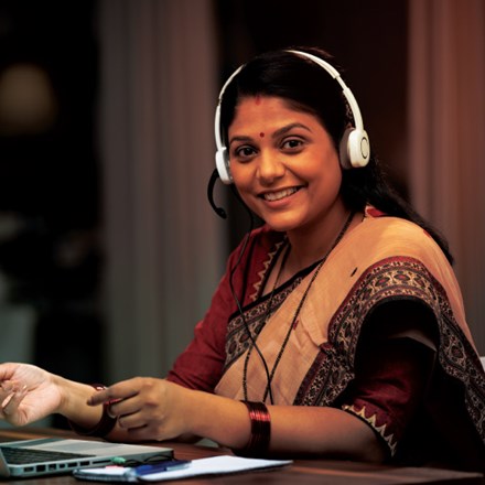 Happy Customer Service Rep with headset using Dynamics 365 Customer Service