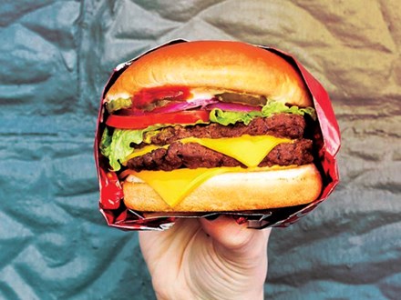 Hand holding a Wendy's burger in all its glory.