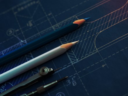 Drawing tools lying over blueprint paper.